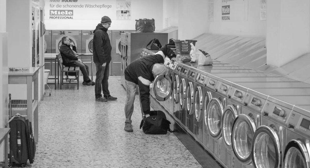 Laundromat interior with people using washing machines, Berlin.