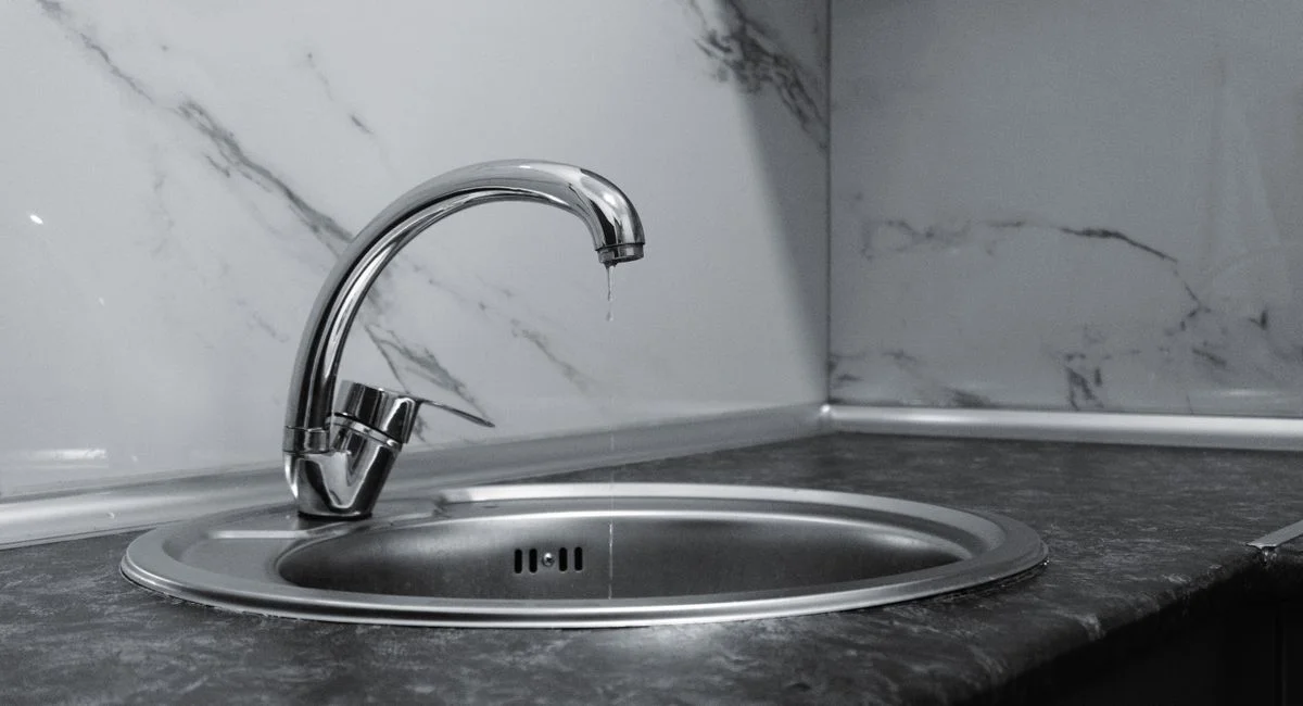A clean and modern kitchen sink with a chrome faucet, highlighting minimalist design and water conservation.