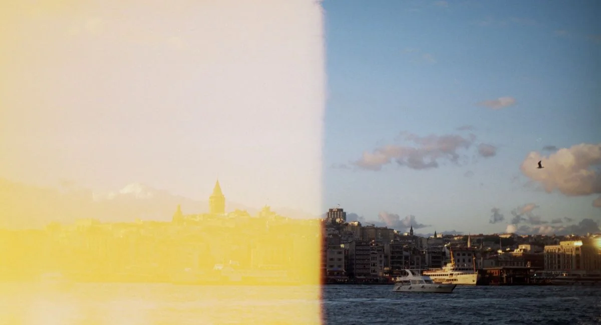 City skyline with a unique light leak effect, capturing a serene waterfront view.