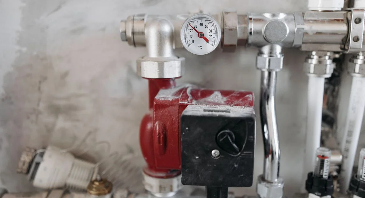 Close-up view of an industrial plumbing system featuring a pressure gauge and steel pipes.