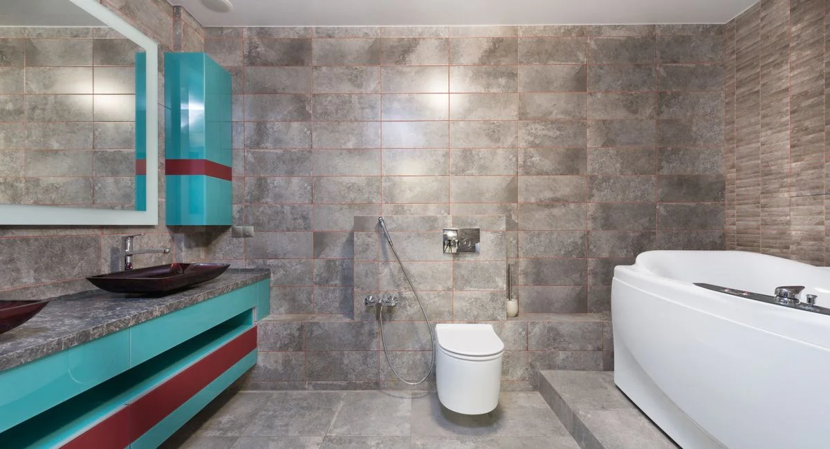 Interior of contemporary bathroom with modern toilet and bathtub with mirror hanging above sink